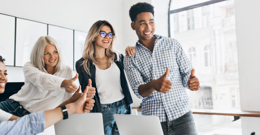 tall-african-manager-with-big-smile-holding-thumbs-up-looking-away-charming-girls-working-as-managers-posing-office-table-with-laptops-it-laughing (1) tall-african-manager-with-big-smile-holding-thumbs-up-looking-away-charming-girls-working-as-managers-posing-office-table-with-laptops-it-laughing (1)